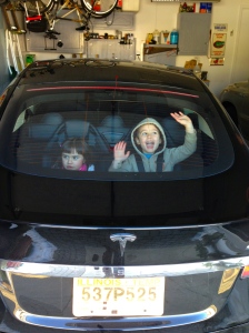 The kids strapped in the back of the Tesla, ready for a ride!